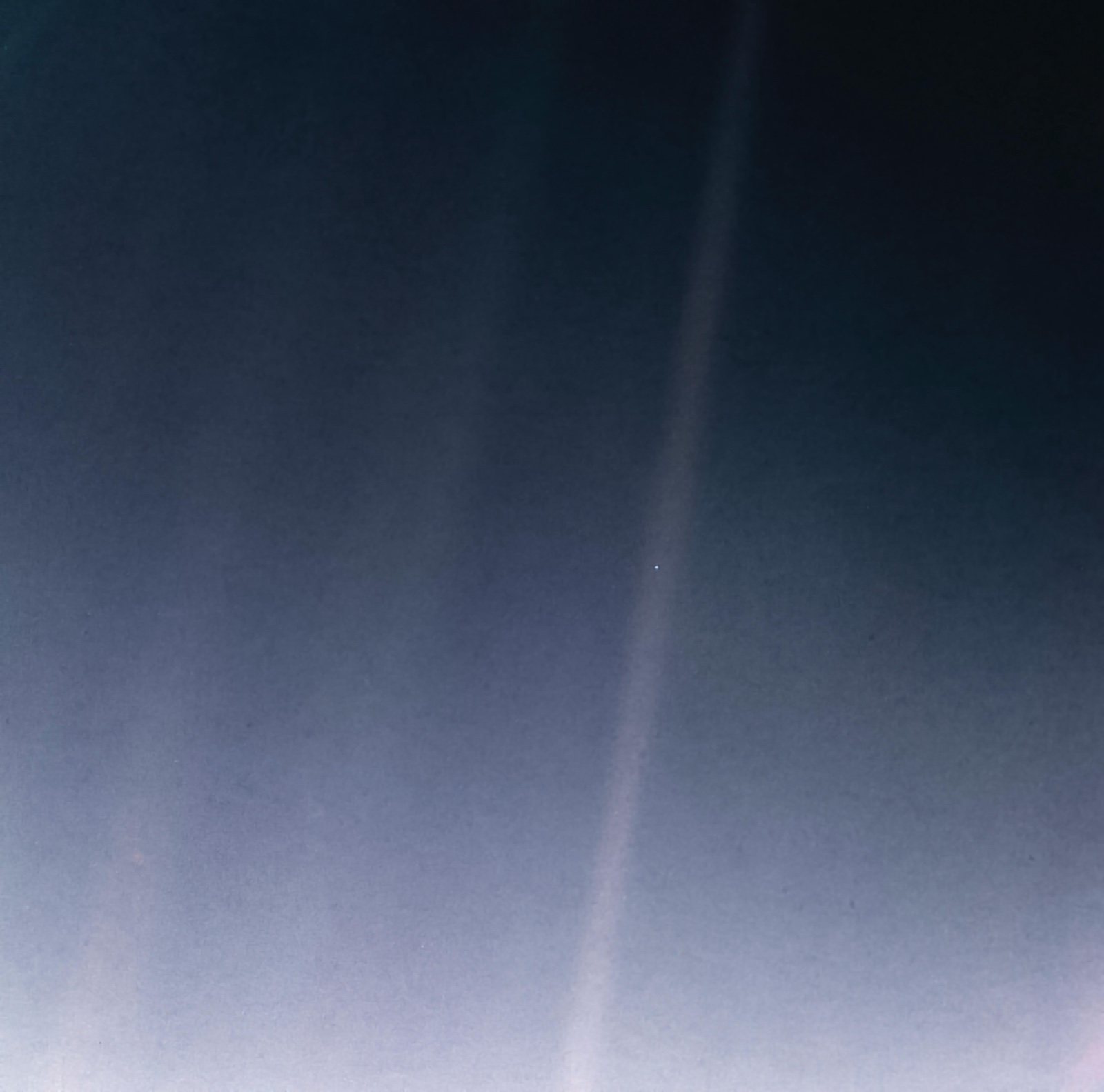 Earth as a fraction of a pixel inside a band of scattered sunlight, photographed by Voyager 1